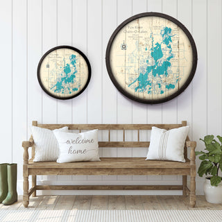 Two circular wall art pieces with blue designs on a white wooden wall above a wooden bench with a 'welcome home' pillow.