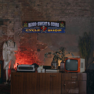 Blood Sweat & Gears - Wood & Metal Wall Art mounted on brick wall above vintage decor and wooden cabinet.